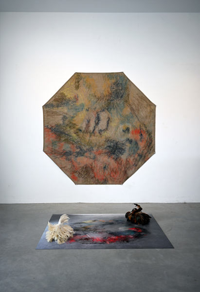 Octagonal art work on the wall and a square installation on the floor